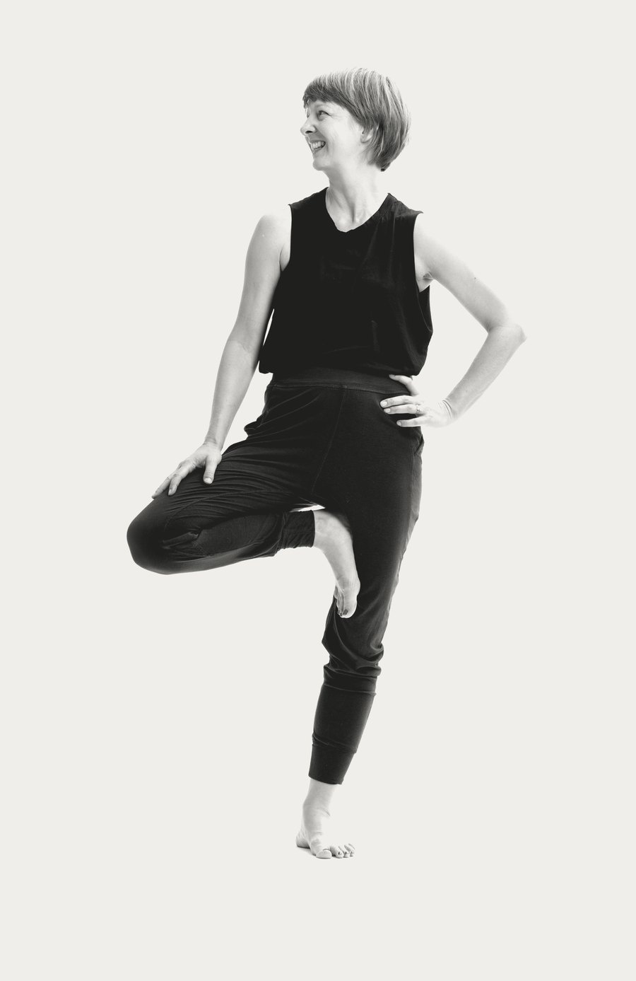 Sabine Klein lacht und steht im Yoga auf einem Bein.